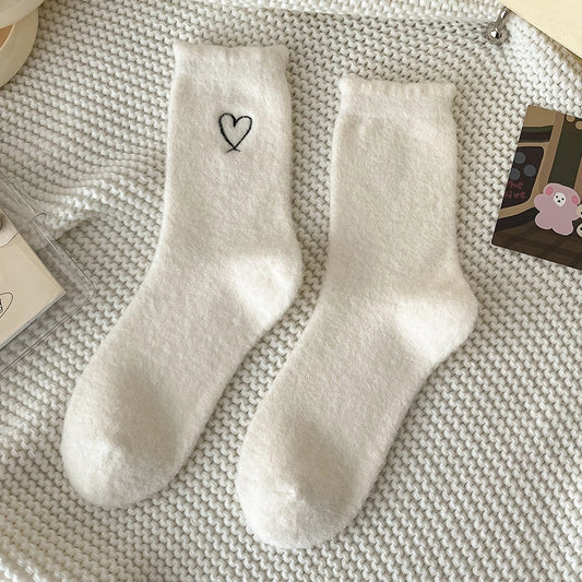 Cream Warm Velvet Heart Socks with black heart embroidery, laid flat on a white knitted background.